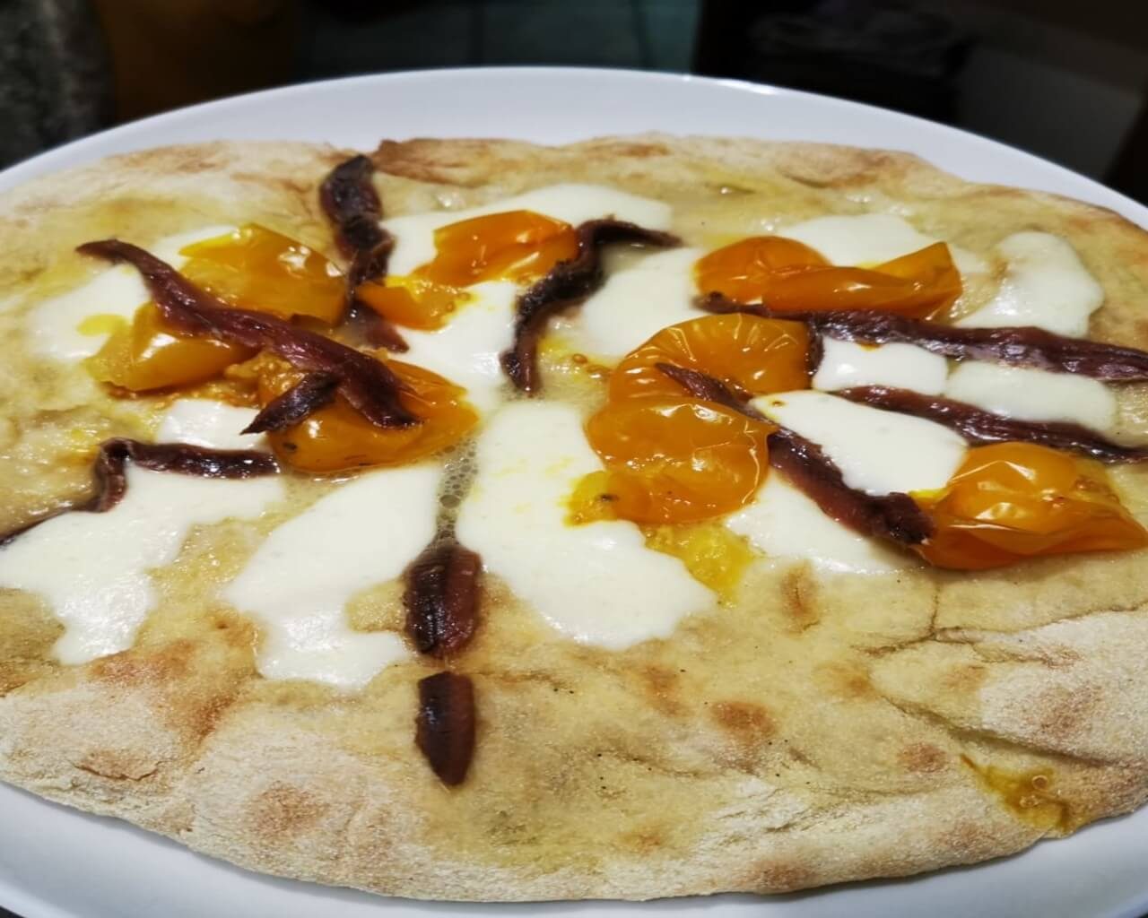 pizza con pomodori gialli e alici