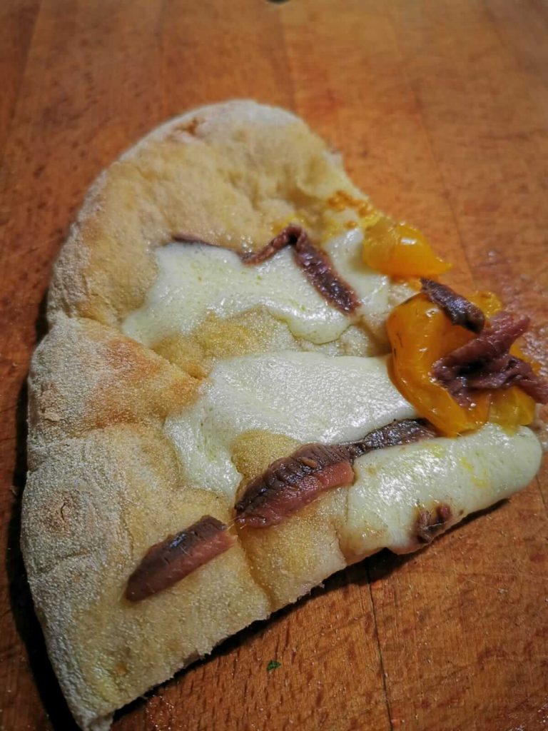 fetta di pizza alici e pomodori gialli